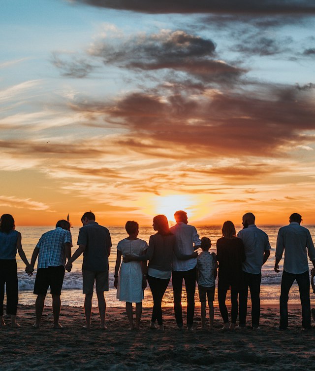 Families standing together at sunset